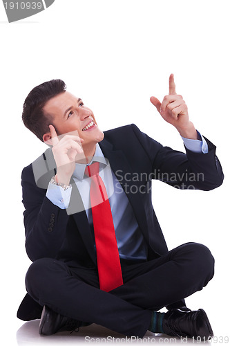 Image of young seated business man pointing