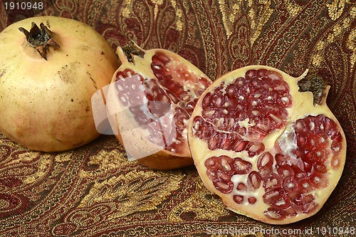 Image of two pomegranates, one open in the foreground and the background another whole