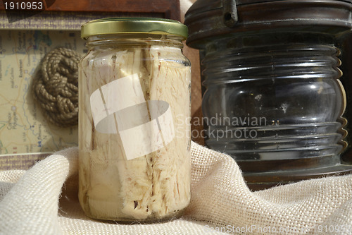 Image of tuna canned in glass jar and maritime motifs