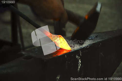 Image of blacksmith forging a metal pin 