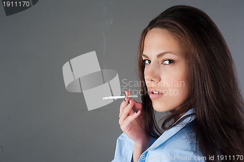 Image of beautiful young brunette woman with cigarette