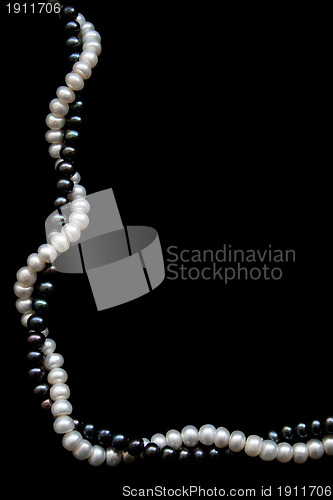 Image of White and black pearls on a black velvet 