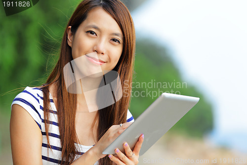 Image of young asian woman with tablet outdoor