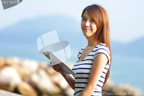 Image of young asian woman with tablet outdoor