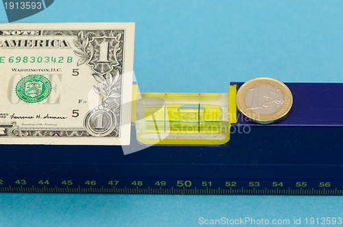 Image of level tool usd dollar banknote euro coin on blue 