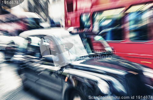 Image of Motion blur picture of Black Cab and Red Double Decker Bus in th