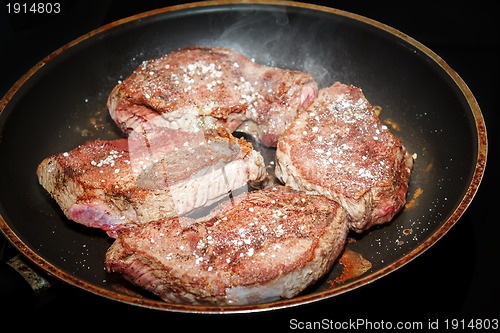 Image of beef meat on pan with pepper and sea salt