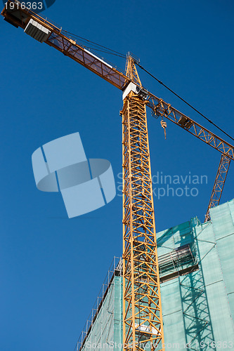 Image of Construction site: crane and unfinished buiding