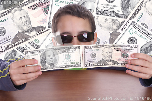 Image of boy blinded by money, studio photo