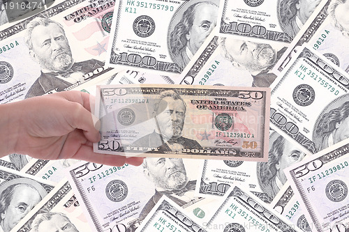 Image of hand holding a dollar bill, business studio photo