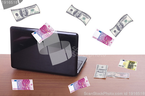 Image of money flying and pouring out from a notebook computer