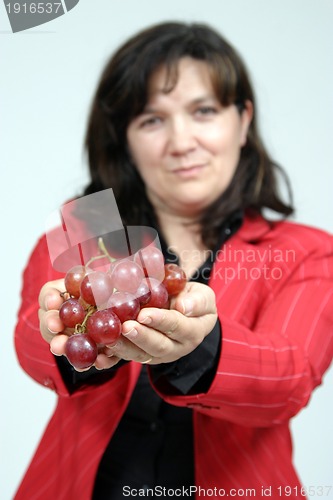 Image of beautiful woman with red grapes, healthy food