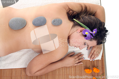 Image of attractive woman with hot stones treatment at a spa