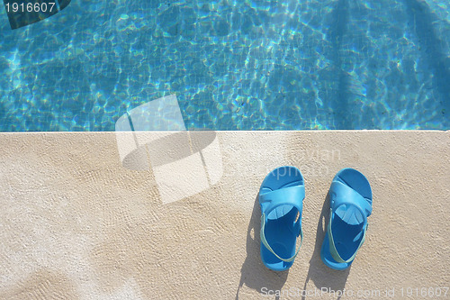 Image of Slippers near swimming pool, summer vacations