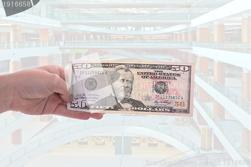 Image of hand holding a dollar bill, business studio photo