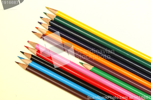 Image of Assortment of coloured pencils with shadow on white background