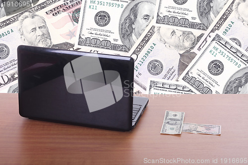 Image of money flying and pouring out from a notebook computer