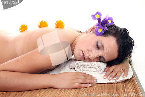 Image of attractive woman with hot stones treatment at a spa