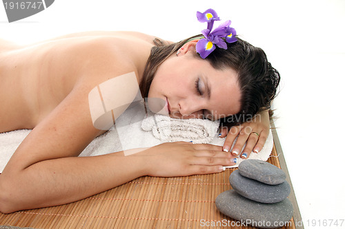 Image of attractive woman with hot stones treatment at a spa