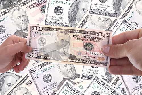 Image of hand holding a dollar bill, business studio photo