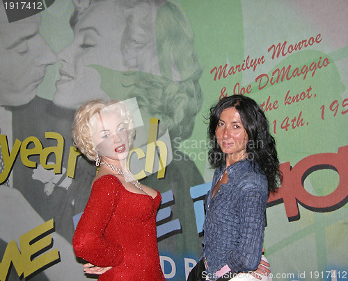 Image of Girl Poses alongside Marylin Monroe inside Wax Museum in NYC