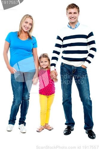 Image of Sweet little kid standing in between her parents