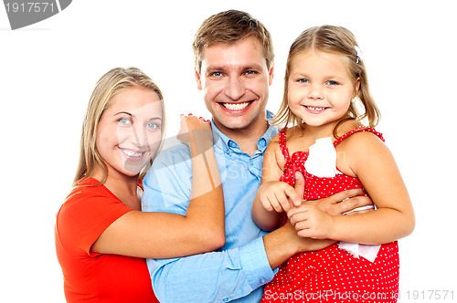 Image of Cheerful family of three facing camera and smiling