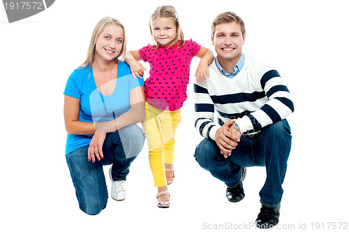 Image of Trendy couple squatting with girl child in between