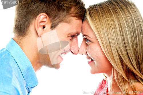 Image of Smiling couple posing. Foreheads touching