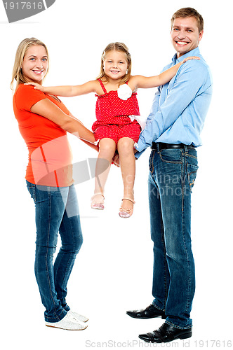 Image of Baby girl sitting on outstretched arms of her parents