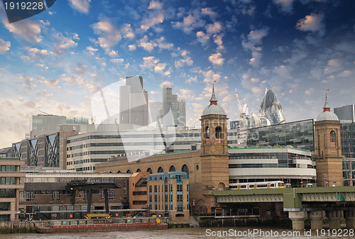 Image of City of London with clouds, financial center and Canary Wharf at