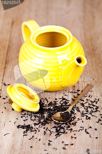 Image of yellow teapot with spoon and tea 