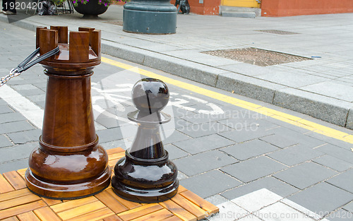 Image of outdoor chess game figures near bicycle path 
