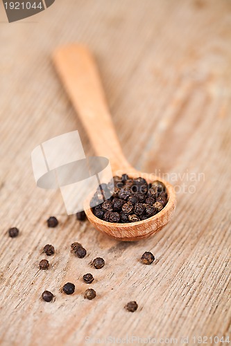 Image of black pepper in wooden spoon