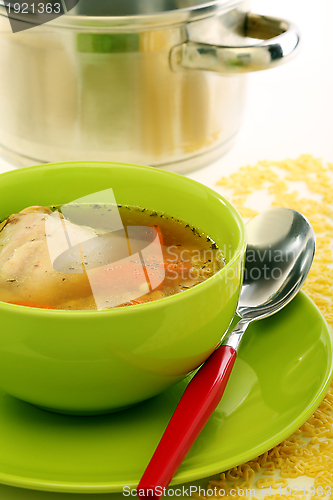 Image of Chicken soup in a green bowl.