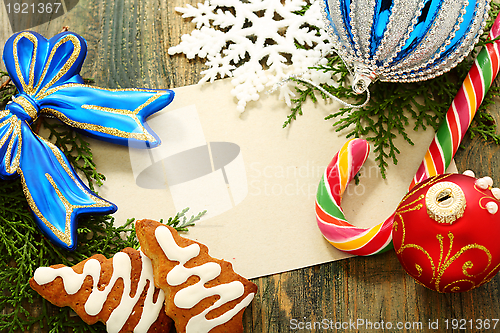 Image of Christmas card with balls, candy and snowflakes.