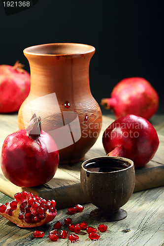 Image of Ripe pomegranate and juice in cup.
