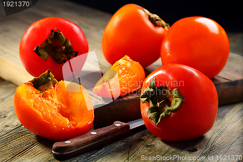 Image of  Ripe persimmons and knife.