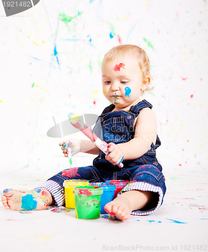 Image of cute little baby painting and splatter with colours