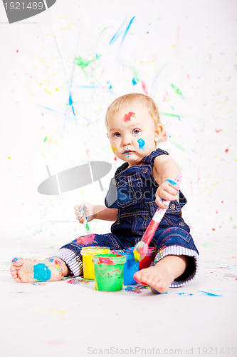 Image of cute little baby painting and splatter with colours