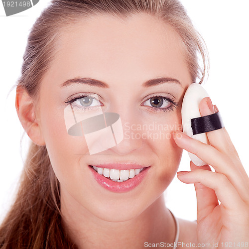 Image of beautiful woman applying make up on face