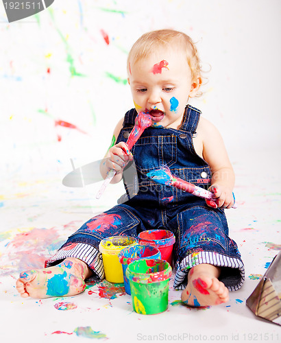 Image of cute little baby painting and splatter with colours