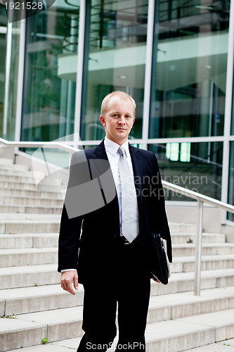 Image of young business man in black suit with tie outdoor