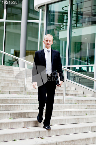 Image of young business man in black suit with tie outdoor