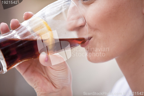 Image of young woman is drinking lemonade outside in summer