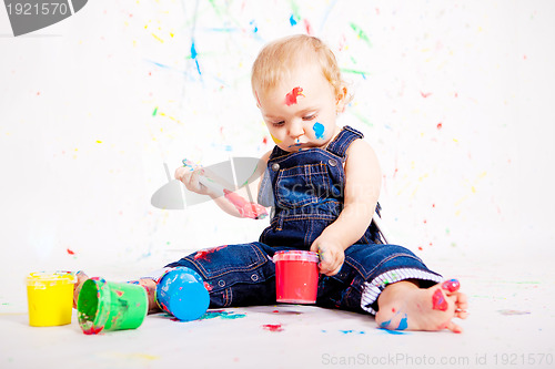 Image of cute little baby painting and splatter with colours