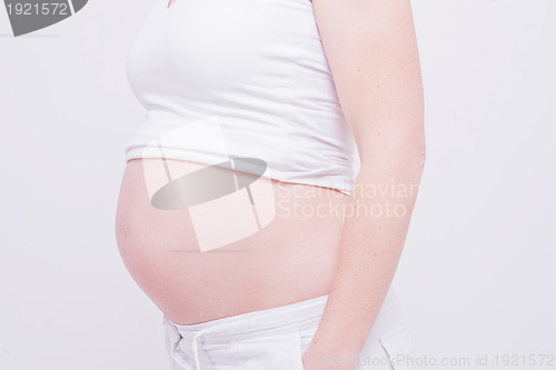 Image of pregnant woman shows belly on white