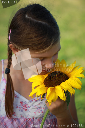 Image of Young girl smelling a sunflower