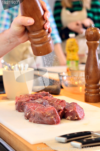 Image of Man is salting a meat