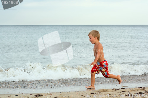 Image of Little boy running at the seashore
